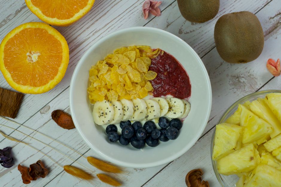 A vibrant breakfast bowl with fresh fruits and cereal on a wooden table.
