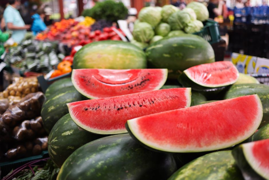 A vibrant display of watermelon slices and other fresh produce at an outdoor market, capturing the essence of summer.