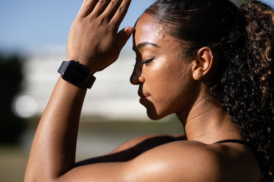 Side profile of a woman meditating outdoors in sunlight, wearing a smartwatch.