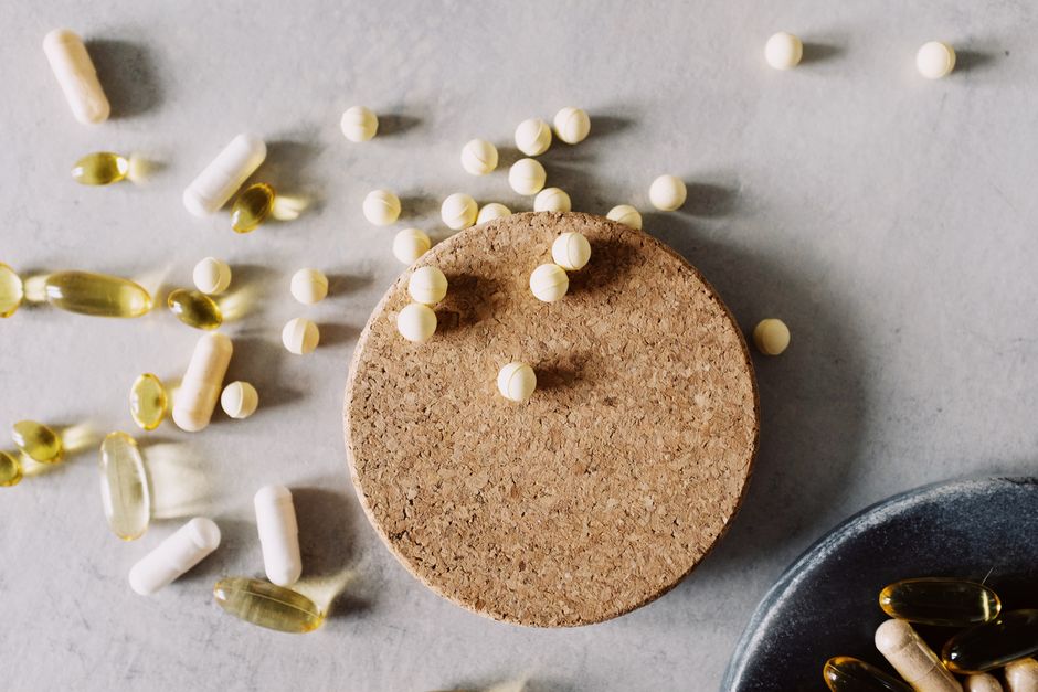 Assorted pills and capsules on a marble surface, highlighting healthcare and medicine.