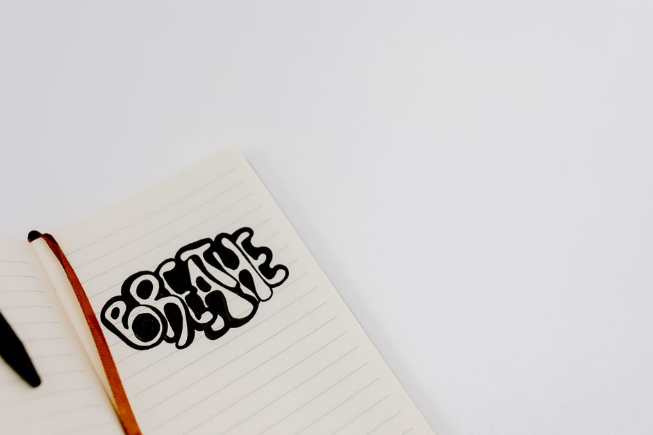 Close-up of an open notebook with 'Breathe' sketch, featuring ample copy space for personal or professional use.