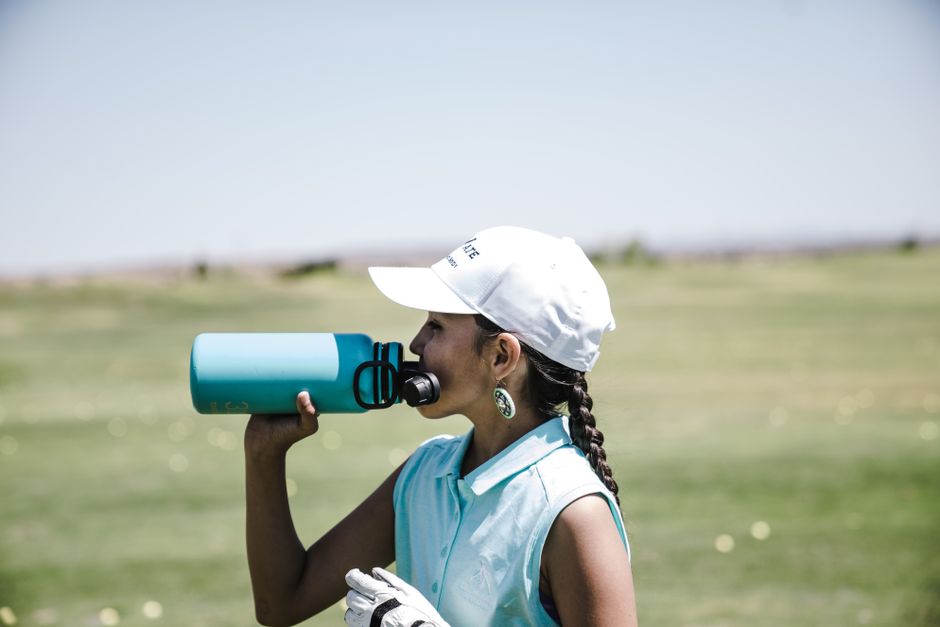 Woman drinking water from a bottle on a hot summer day